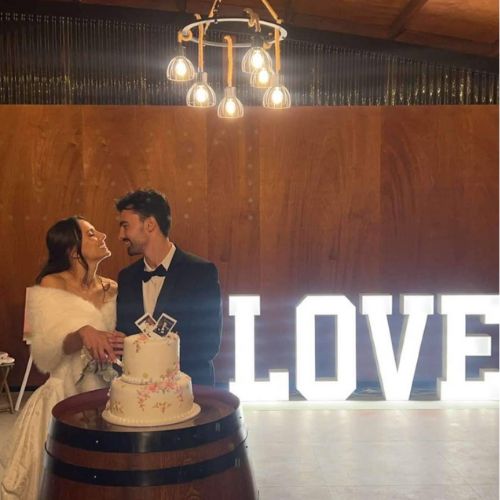 Bride and groom cutting wedding cake in barn reception at Western Ridge Wedding Venue